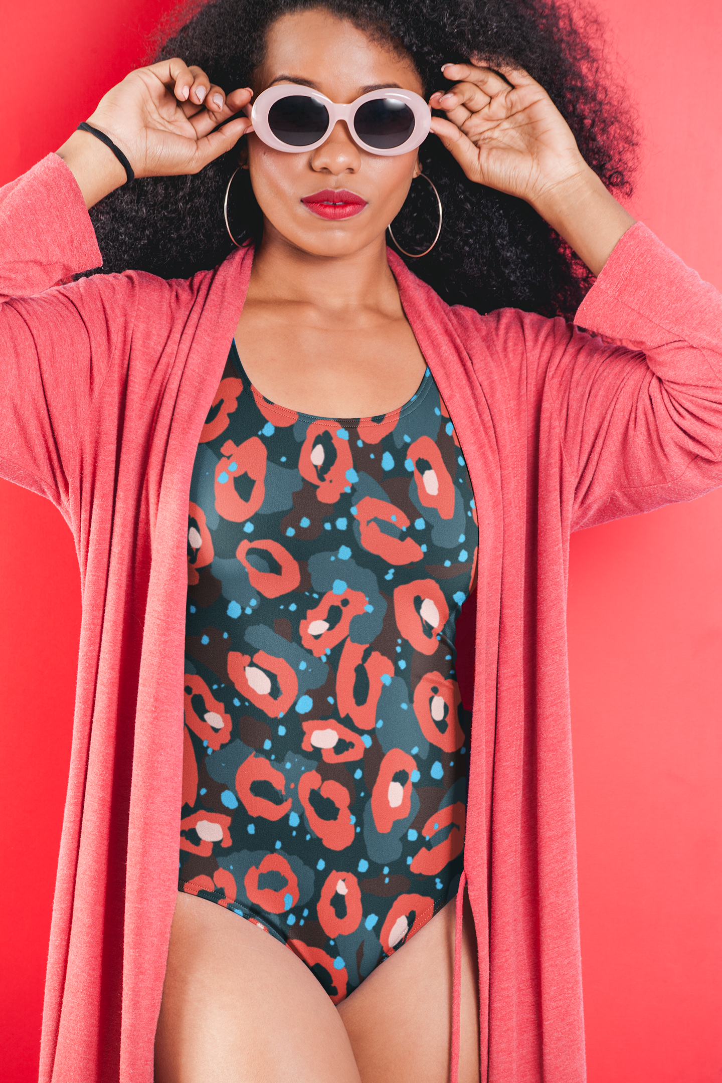 Woman-with-sunglasses-wearing-a-uneek-one-piece-swimsuit-with-leopard-print-under-a-robe